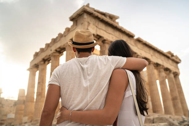 rear view of a young couple embracing standing in the acropolis, athens